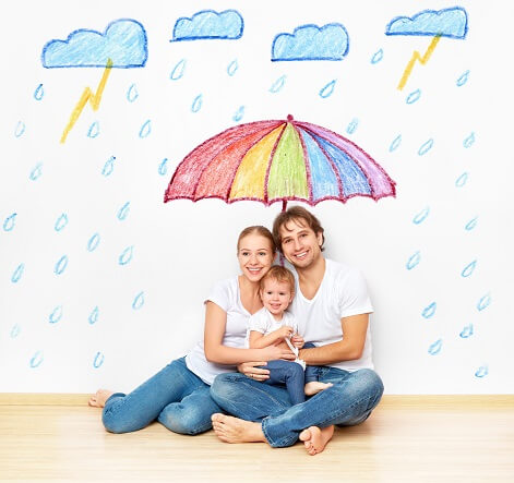 Family sitting under an umbrella